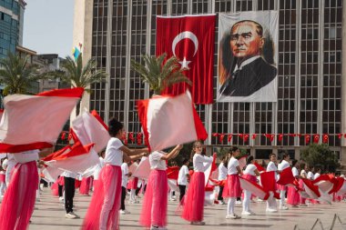 İzmir, Türkiye 23 Nisan 2024 Kırmızılı ve beyazlı çocukların Ulusal Egemenlik ve Çocuk Günü boyunca arkaplanı süsleyen Türk bayrakları ve Atatürk 'ün portresiyle yaptıkları neşeli dans.