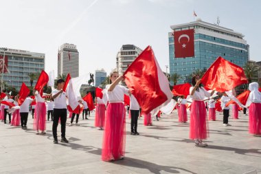 İzmir, Türkiye - 23 Nisan 2024: Kırmızılı ve beyazlı genç öğrenciler, Türkiye 'nin Ulusal Egemenlik ve Çocuk Günü kutlamaları sırasında İzmir Cumhuriyet Meydanı' nda bayrak dansı yaptılar
