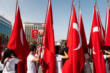 İzmir, Türkiye - 23 Nisan 2024: İzmir Cumhuriyet Meydanı 'nda, ellerinde Türk bayrakları bulunan çocuklar 23 Nisan 2024' te düzenlenen festival kutlamaları sırasında Ulusal Egemenlik ve Çocuk Günü geçit töreninin başlamasını bekliyorlar.