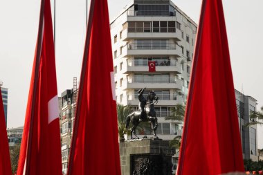 İzmir, Türkiye - 23 Nisan 2024: İzmir 'de düzenlenen Ulusal Egemenlik ve Çocuk Günü kutlamaları sırasında, Türk bayrakları tarafından çerçevelenen Atatürk' ün binicilik heykeli Cumhuriyet Meydanı 'nda gururla duruyor