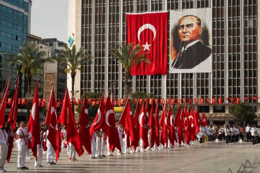 İzmir, Türkiye - 23 Nisan 2024: Ulusal Egemenlik ve Çocuk Günü töreninde elinde Türk bayraklarıyla Cumhuriyet Meydanı 'nı denetleyen büyük bir Atatürk bayrağıyla resmi bir heyet.