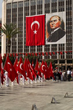 İzmir, Türkiye - 23 Nisan 2024: Ulusal Egemenlik ve Çocuk Günü töreninde elinde Türk bayraklarıyla Cumhuriyet Meydanı 'nı denetleyen büyük bir Atatürk bayrağıyla resmi bir heyet.
