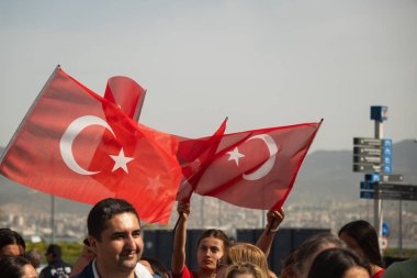 İzmir, Türkiye - 23 Nisan 2024: Türk bayraklı izleyiciler İzmir 'deki Cumhuriyet Meydanı' nda düzenlenen Ulusal Egemenlik ve Çocuk Günü kutlamaları sırasında bir araya geldiler