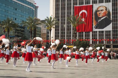 İzmir, Türkiye 23 Nisan 2024 Kırmızılı ve beyazlı çocukların Ulusal Egemenlik ve Çocuk Günü boyunca arkaplanı süsleyen Türk bayrakları ve Atatrk 'ın portresiyle yaptıkları neşeli dans.
