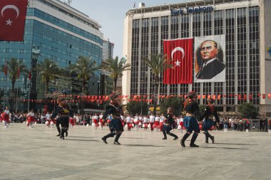 İzmir, Türkiye - 23 Nisan 2024: Geleneksel Zeybek kıyafeti giymiş çocuklar, Türk bayrakları ve Atatürk portresiyle Cumhuriyet Meydanı 'nda Milli Egemenlik ve Çocuk Günü için ikonik dansı yaptılar