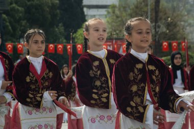 İzmir, Türkiye - 23 Nisan 2024: Geleneksel Türk kostümlü kızların Cumhuriyet Meydanı 'ndaki Ulusal Egemenlik ve Çocuk Günü kutlamaları sırasında dans etmeleri