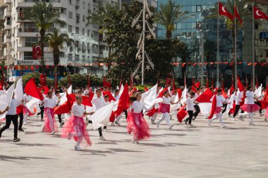 İzmir, Türkiye - 23 Nisan 2024: Türkiye 'nin Ulusal Egemenlik ve Çocuk Günü kutlamaları sırasında İzmir Cumhuriyet Meydanı' nda kırmızı ve beyaz giyinmiş genç kız öğrenciler bayrak dansı yaptılar