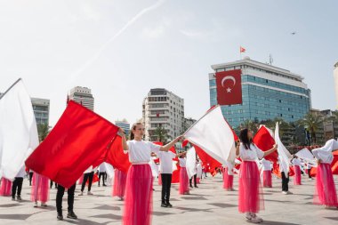 İzmir, Türkiye - 23 Nisan 2024: Türkiye 'nin Ulusal Egemenlik ve Çocuk Günü kutlamaları sırasında İzmir Cumhuriyet Meydanı' nda kırmızı ve beyaz giyinmiş genç kız öğrenciler bayrak dansı yaptılar