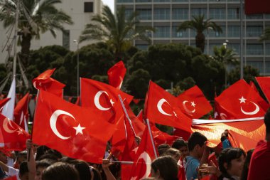 İzmir, Türkiye - 23 Nisan 2024: Coşkulu Türk öğrenciler, İzmir 'in hareketli Cumhuriyet Meydanı' nda Ulusal Egemenlik ve Çocuk Günü ruhunu kucaklayarak bayrağını sallıyorlar
