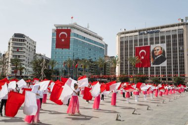 İzmir, Türkiye 23 Nisan 2024 Kırmızılı ve beyazlı çocukların Ulusal Egemenlik ve Çocuk Günü boyunca arkaplanı süsleyen Türk bayrakları ve Atatrk 'ın portresiyle yaptıkları neşeli dans.