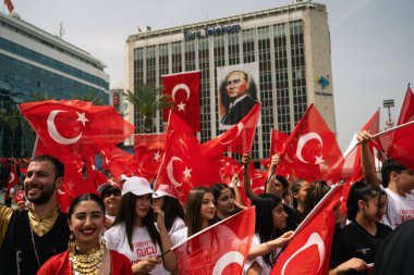 İzmir, Türkiye - 19 Mayıs 2024: Cumhuriyet Meydanı 'nda Gençlik ve Spor Günü ve Atatürk Anma Günü kutlamaları sırasında Türk bayraklarıyla yürüyen genç sporcular