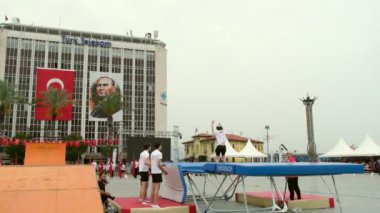İzmir, Türkiye - 19 Mayıs 2024: Cumhuriyet Meydanı 'nda düzenlenen Gençlik, Spor ve Atatürk Günü kutlamaları sırasında jimnastik grubu trambolin atlama gösterisi düzenledi