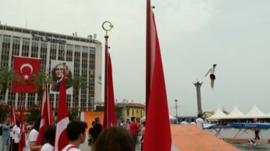 İzmir, Türkiye - 19 Mayıs 2024: Cumhuriyet Meydanı 'nda düzenlenen Gençlik, Spor ve Atatürk Günü kutlamaları sırasında jimnastik grubu trambolin atlama gösterisi düzenledi