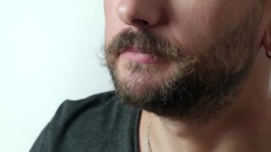 Bir adamın pizza diliminden bir ısırık alışını gösteren yakın plan bir video, pizzanın dokusunu ve yerken adamın ağzını vurguluyor.