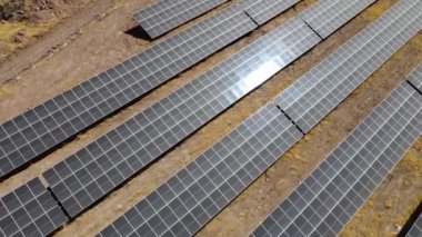 Açık bir alana yayılmış geniş bir dizi güneş panelinin hava görüntüsü güneşten gelen temiz enerjiyi yakalıyor. İnsansız hava aracı yenilenebilir enerji teknolojisinin planını yakalıyor.