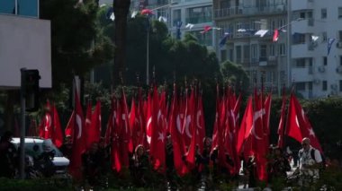 İzmir, Türkiye - 29 Ekim 2024: Liseli kızlar, Cumhuriyet Günü kutlamalarında Türk bayraklarıyla yürüyüş yaparak ulusal gurur ve birlik gösterdiler. Ağır çekimde yakalandı.