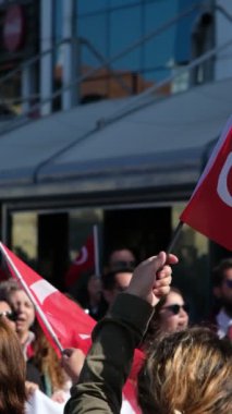 İzmir, Türkiye - 29 Ekim 2024: Halk, ulusal bayram onuruna düzenlenen Cumhuriyet Günü kutlamalarını izlerken Türk bayrakları sallıyor. Ek etki için yavaş çekimde yakalanır