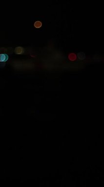 Sahil Güvenlik botlarından mavi ve kırmızı polis ışıkları yanıp sönüyor. Suda canlı bokeh etkileri yaratıyor. Gece sahnesini büyütüyor.