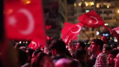 İzmir, Türkiye - 29 Ekim 2024: Cumhuriyet Günü kutlamaları için Gndodu Meydanı 'nda düzenlenen ücretsiz bir konser sırasında, insanlar Türk bayraklarını sallıyor ve festival atmosferinin keyfini çıkarıyorlar. Ağır çekimde yakalandı.