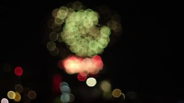 Bir kutlama sırasında gökyüzüne fırlatılan havai fişeklerin canlı bokeh etkisini gösteren yavaş çekim bir video. Bulanık renkler büyüleyici bir görsel etki yaratıyor.