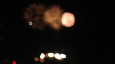 Bir kutlama sırasında gökyüzüne fırlatılan havai fişeklerin canlı bokeh etkisini gösteren yavaş çekim bir video. Bulanık renkler büyüleyici bir görsel etki yaratıyor.