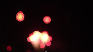 Bir kutlama sırasında gökyüzüne fırlatılan havai fişeklerin canlı bokeh etkisini gösteren yavaş çekim bir video. Bulanık renkler büyüleyici bir görsel etki yaratıyor.