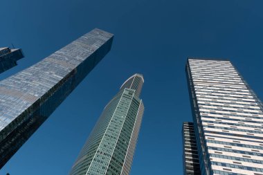 Moskova, Rusya - 19 Ağustos 2024: Moskova 'daki gökdelenlerin mimari fotoğrafı, modern kentsel mimari ve yüksek binalar sergilenen açık mavi gökyüzü arkaplanına karşı.