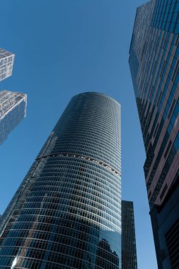 Moskova, Rusya - 19 Ağustos 2024: Moskova 'daki gökdelenlerin mimari fotoğrafı, modern kentsel mimari ve yüksek binalar sergilenen açık mavi gökyüzü arkaplanına karşı.