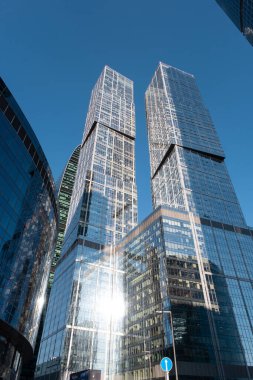 Moskova, Rusya - 19 Ağustos 2024: Moskova 'daki gökdelenlerin mimari fotoğrafı, modern kentsel mimari ve yüksek binalar sergilenen açık mavi gökyüzü arkaplanına karşı.