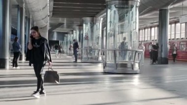 Moskova, Rusya - 15 Ağustos 2024: Moskova 'da aydınlık bir metro istasyonunda yürüyen ve etkileşime giren insanların modern mimari ve hareketli faaliyetlerinin yer aldığı bir video
