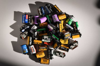 İzmir, Türkiye - Ocak 05 2025: Aralarında Kodak, Fujicolor ve diğerlerinin de bulunduğu 35 mm 'lik çeşitli negatif film kartuşlarının ayrıntılı bir yakın çekimi bir yüzey üzerinde bir araya getirildi