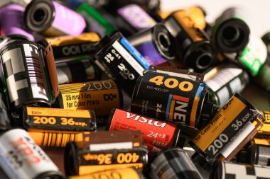 İzmir, Türkiye - Ocak 05 2025: Aralarında Kodak, Fujicolor ve diğerlerinin de bulunduğu 35 mm 'lik çeşitli negatif film kartuşlarının ayrıntılı bir yakın çekimi bir yüzey üzerinde bir araya getirildi