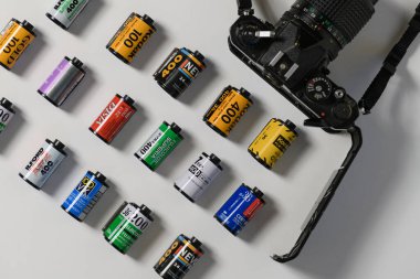 İzmir, Türkiye - Ocak 05 2025: Bir Nikon film kamerası, analog meraklıları için klasik fotoğraf makinesi sergilenen 35 mm 'lik negatif film kartuşlarının yanında dikkatlice yerleştirildi