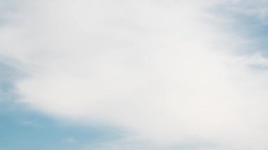 Pofuduk beyaz bulutların dinamik hareketlerini gösteren 34 saniyelik bir zaman dilimi videosu açık mavi gökyüzünde doğanın hareketli güzelliğini gözler önüne seriyor.