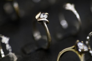 Pırıl pırıl pırıl pırıl pırıl pırıl pırıl bir elmas yüzüğün detaylı bir yakın çekimi, lüks bir ortamda diğer mücevherler arasında zarif bir şekilde sergileniyor..