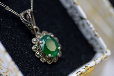 Kaliteli gümüş ayarı olan yeşil değerli bir kolyenin güzel bir yakın çekimi. Karmaşık işçiliği var.
