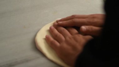 Büyüleyici yavaş çekim yakın çekim mükemmel esneklik ve doku ile taze pizza hamurunu yoğuran eller.