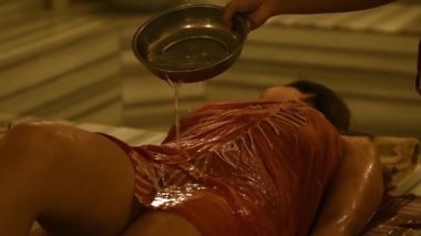 Geleneksel köpük masajının yavaş çekimde zarif otel hamam kaplıcasında kadına uygulanması.
