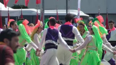 İzmir, Türkiye - 19 Mayıs 2025: Geleneksel Türk kostümlü insanlar ulusal kutlamalar sırasında kent meydanında halk dansı yaptılar