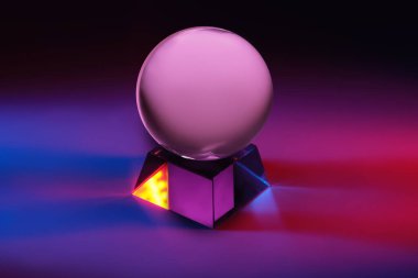 Mavi ve kırmızı ışıklarla boyanmış büyüleyici bir cam küre, uzun pozlama ile çekilen, canlı, ruhani bir ışıltı etkisi yaratan.