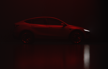 İzmir, Türkiye - 25 Ağustos 2025: Gri bir 2025 Tesla Model Y 'nin stüdyo çekimi, kırmızı ışık altında tam sağdan görüş, siyah arkaplan.