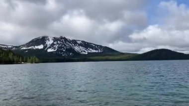 Paulina Gölü 'nün dalgalı sularında karla kaplı Paulina Tepesi bulutlu bir bahar gününde Newberry Volkanı Ulusal Anıtı, Nr Bend, Oregon, ABD