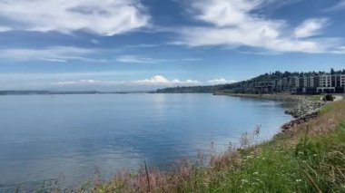 The stunning view of a snowcapped Mt Rainier on a clear day with the urban skyline of Tacoma in the foreground and still, blue waters of Puget Sound - Point Defiance Park, Washington, USA