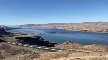 The panoramic view of the mighty Columbia River and Vantage Bridge in Eastern WA with the I90 Interstate and vehicles snaking through the arid landscape - Nr Ellensburg, Washington, USA