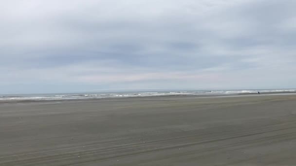 オーシャン ショアーズ ワシントン 2022 砂が州道と考えられているオーシャン ショアーズの静かなビーチに沿って黒い車 太平洋の波が海岸に打ち寄せる — ストック動画