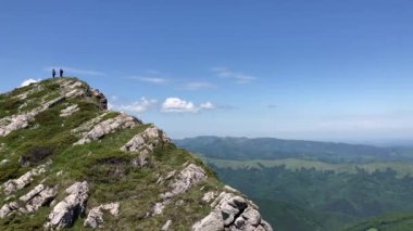 İki kadın yürüyüşçü, mavi gökyüzündeki dik bir dağ sırtından vadi manzarasına hayran, yaz günü - Kozya Stena Reserve, Bulgaristan ve Avrupa