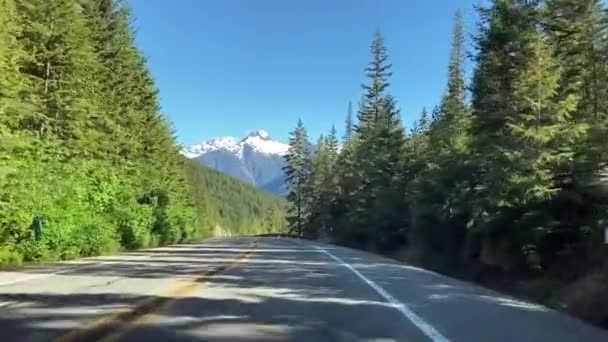 驾车者通过挡风玻璃开车穿过北部级联风景高速公路穿过国家公园 可以看到白雪覆盖的高山和美丽的常绿森林 美国华盛顿 — 图库视频影像
