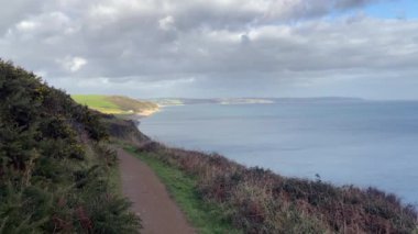 Arka planda Beesand 'ların ve Güney Devon kıyı şeridinin olduğu Güney Batı Sahil Yolu patikasının manzarası ve sakin okyanus. Bulutlu bir günde çekildi - Nr Slapton, Devon, İngiltere