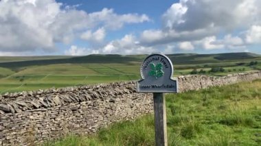 Tipik bir Yorkshire Dales tabelaları önünde National Trust Yukarı Wharfedale tabelası kuru taş duvarlar ve güneşli bir yaz gününde yuvarlanan yeşil tepelerin olduğu güzel bir manzara - Nr Buckden, Kuzey Yorkshire, İngiltere