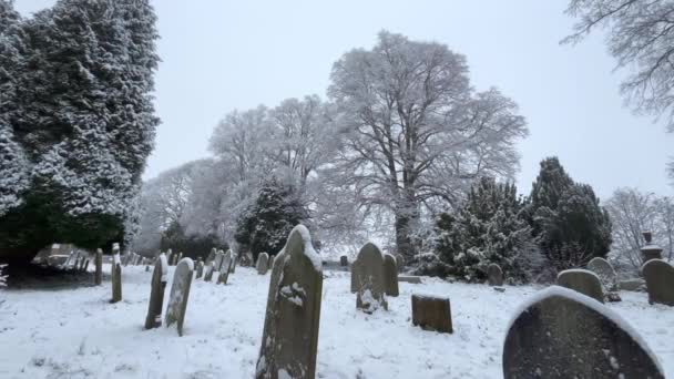 冬の間に新鮮な雪の毛布に覆われた古代の墓地 多数のヘッドストーンをフィーチャー ノースヨークシャー イギリス — ストック動画